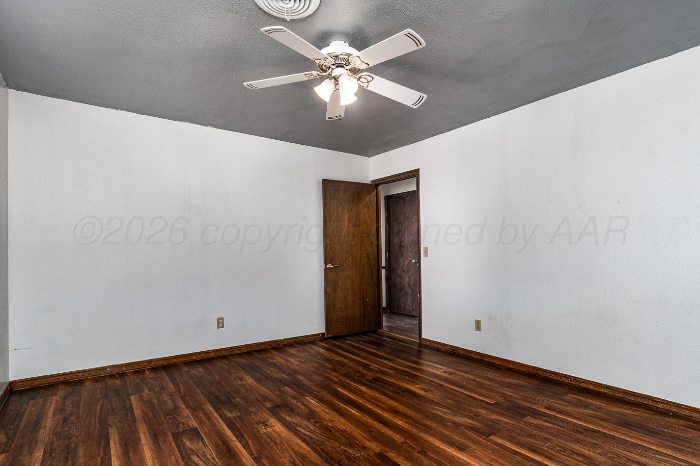 7803 Farrell Drive Amarillo, TX 79121 - Photo 15 of 29 a view of an empty room with window and wooden floor