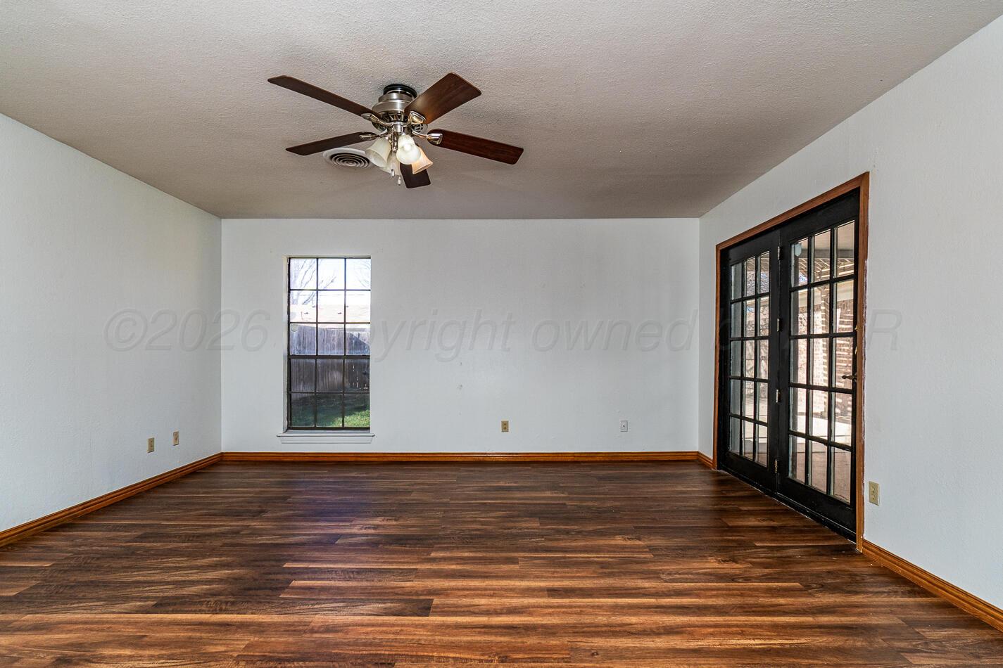 7803 Farrell Drive Amarillo, TX 79121 - Photo 18 of 29 a view of empty room with wooden floor and fan