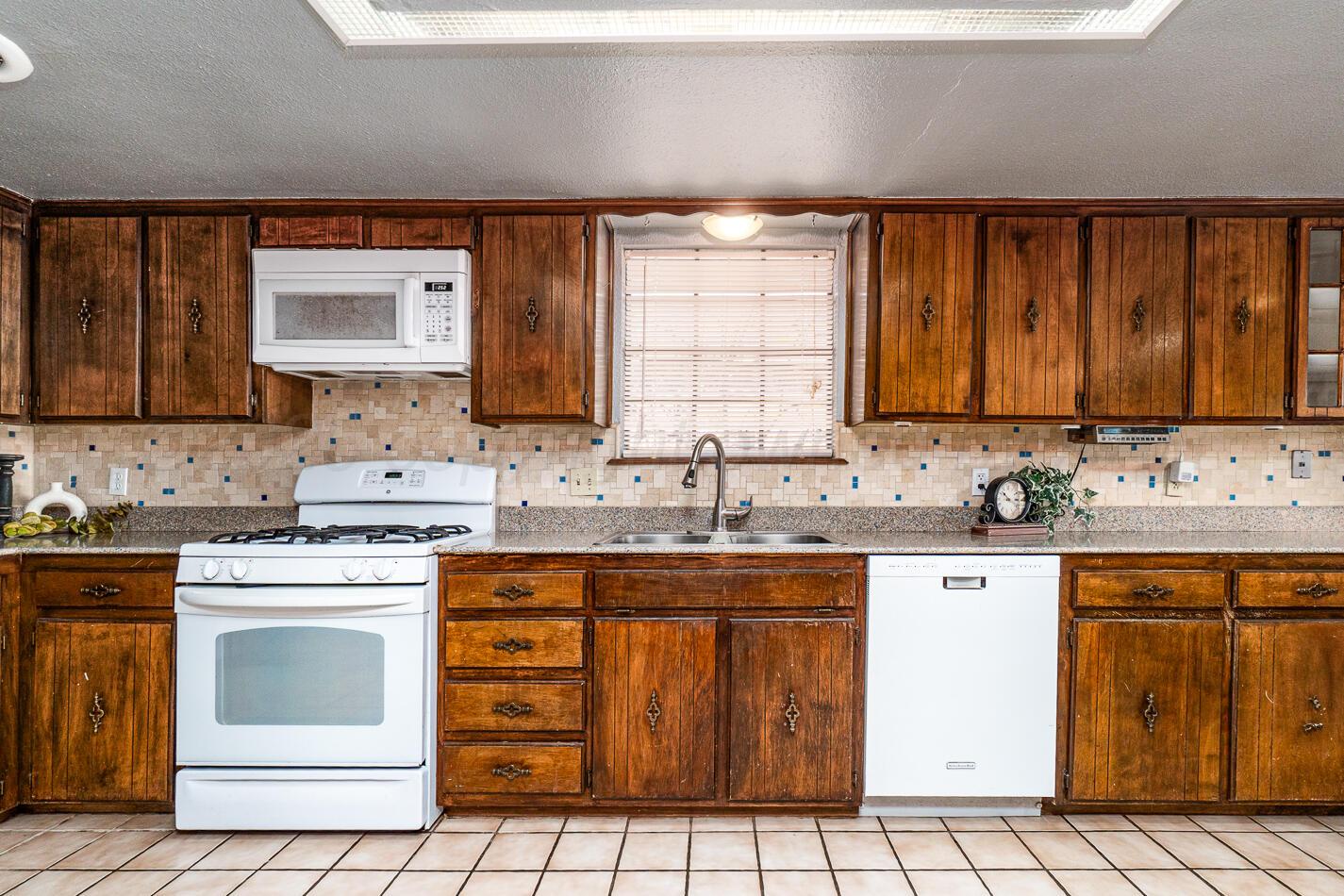 7803 Farrell Drive Amarillo, TX 79121 - Photo 4 of 29 a kitchen with a sink stove and cabinets