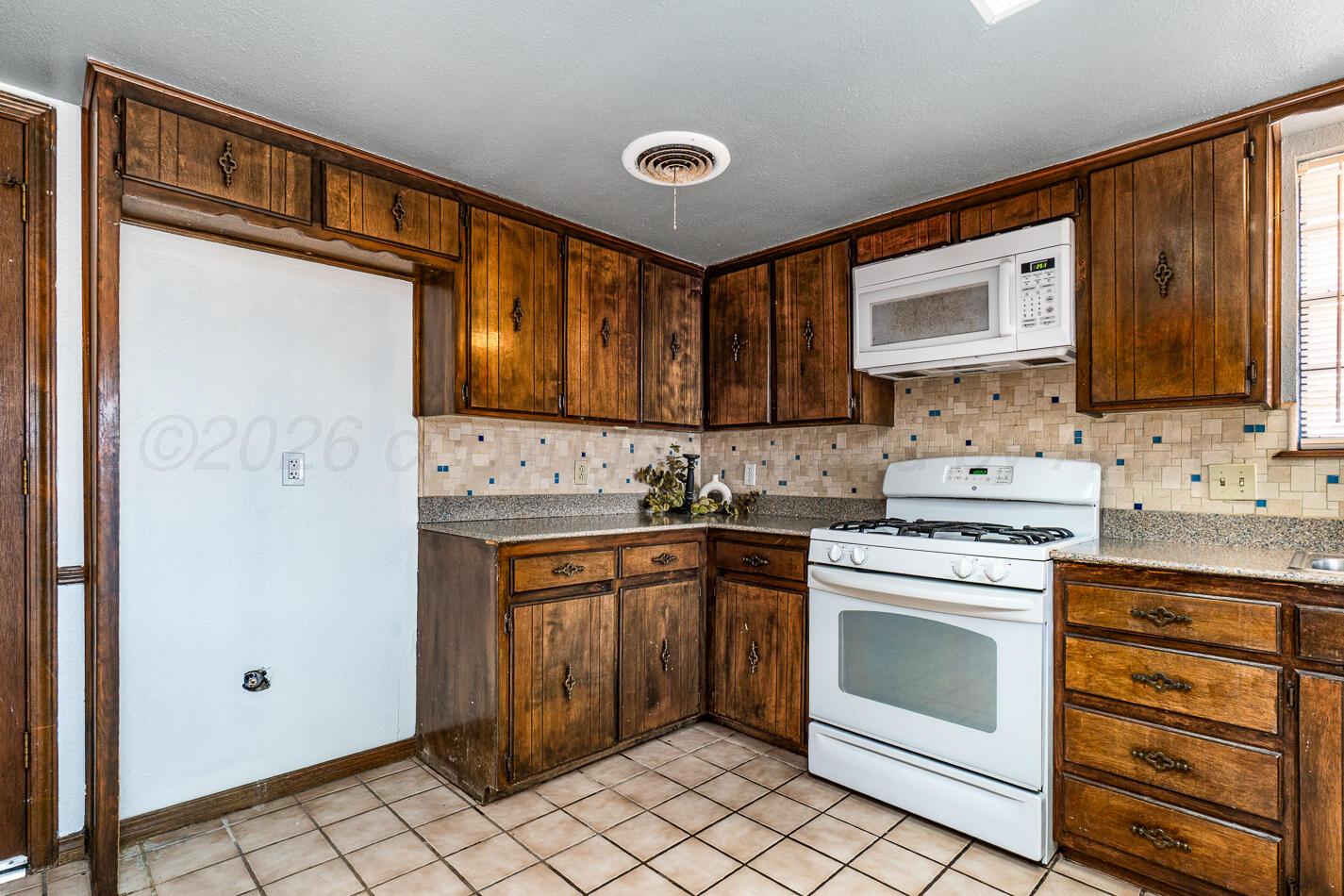 7803 Farrell Drive Amarillo, TX 79121 - Photo 10 of 29 a kitchen with a stove sink and cabinets