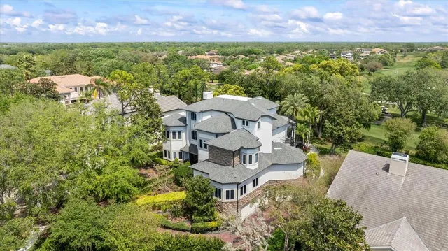 a large white kitchen with kitchen island granite countertop a refrigerator a sink and white cabinets