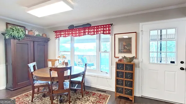 a large kitchen with stainless steel appliances a large counter top a stove a sink a window and dining table