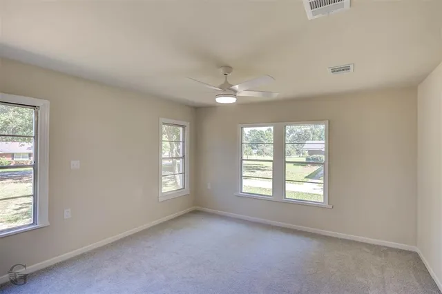 an empty room with windows and closet