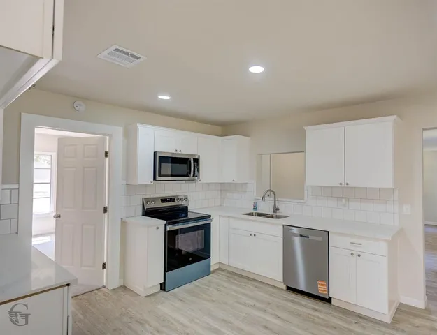 a kitchen with granite countertop a sink and cabinets