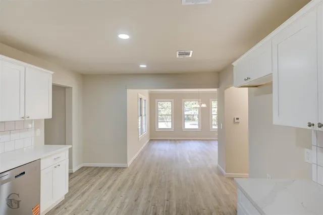 a view of a kitchen with wooden floor and a window