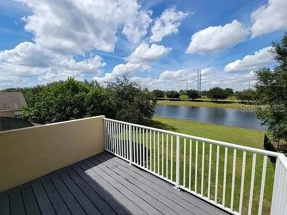 a balcony with wooden floor and lake view