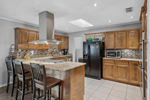 a kitchen with stainless steel appliances granite countertop a stove refrigerator sink and cabinets