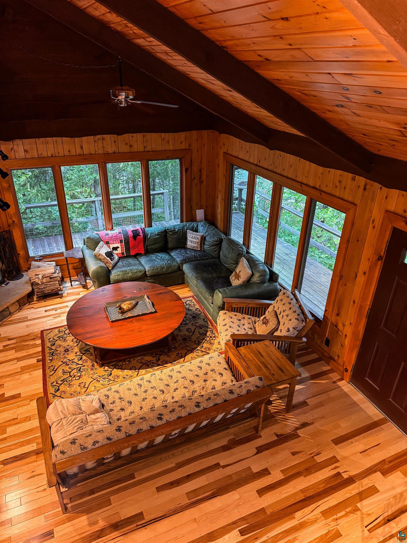 8141 Muskego Point Orr, MN 55771 - Photo 43 of 48 Living room featuring wood ceiling, wooden walls, light wood-style flooring, and a ceiling fan