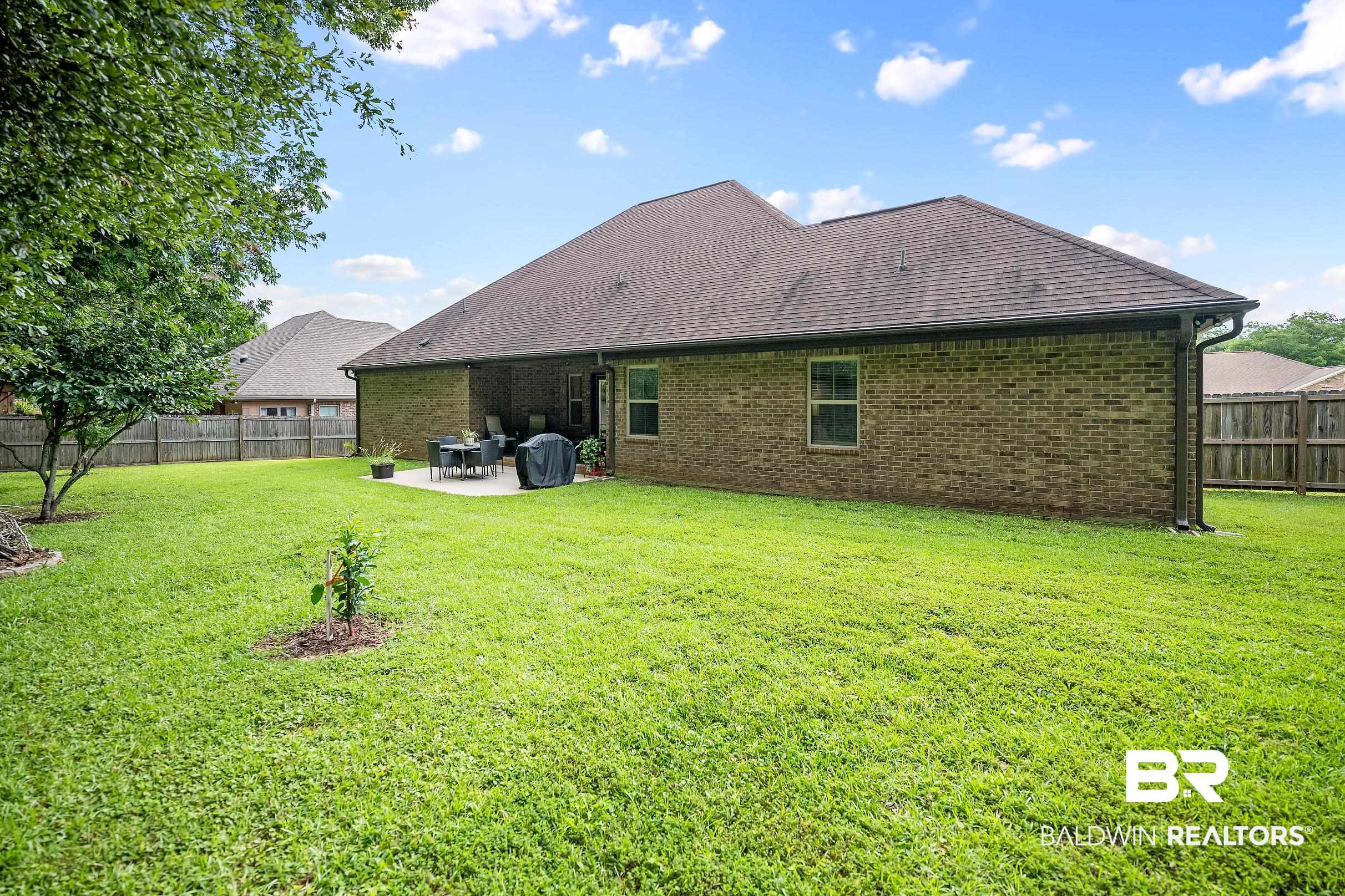 313 Pecan Ridge Boulevard Fairhope, AL 36532 - Photo 30 of 51 Expansive backyard featuring a manicured lawn, a paved patio, and a privacy fence