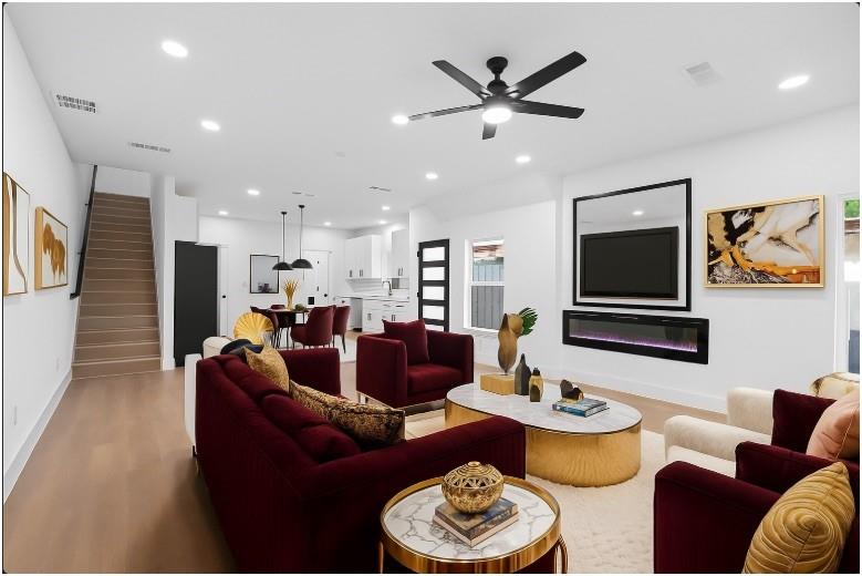 a living room with furniture kitchen view and a flat screen tv