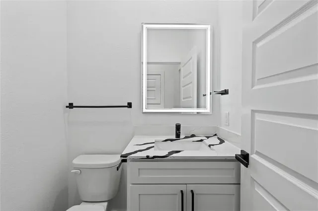 a bathroom with a sink toilet and mirror