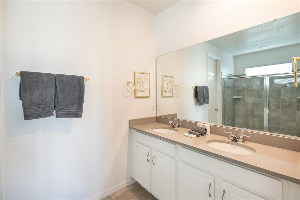 8900 Caroline Bay Court Kissimmee, FL 34747 - Photo 14 of 62 a bathroom with a double vanity sink and mirror