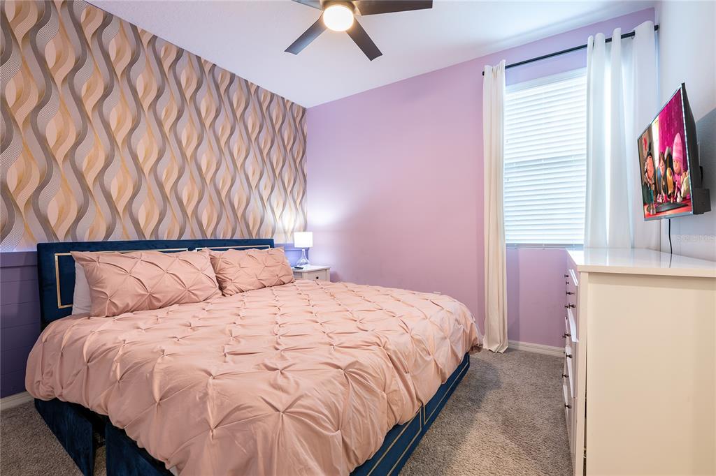 8900 Caroline Bay Court Kissimmee, FL 34747 - Photo 28 of 62 a bedroom with a bed and a chandelier