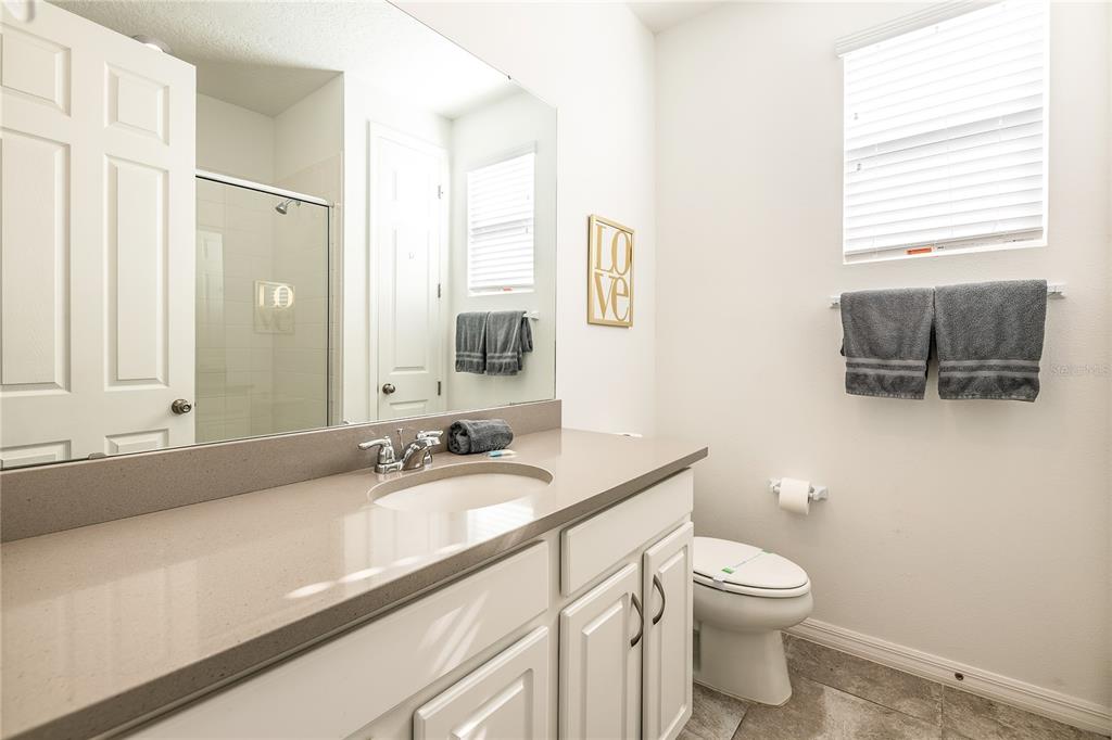 8900 Caroline Bay Court Kissimmee, FL 34747 - Photo 32 of 62 a bathroom with a granite countertop sink a toilet and a mirror