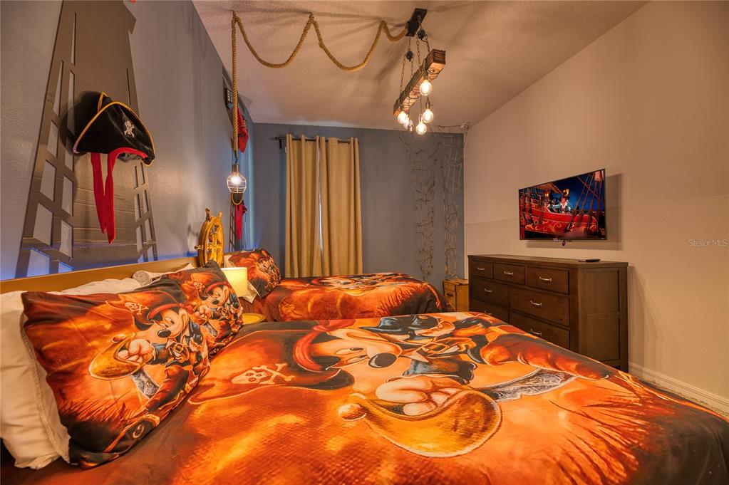 8900 Caroline Bay Court Kissimmee, FL 34747 - Photo 35 of 62 a bedroom with a bed and a chandelier