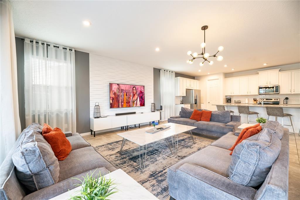 8900 Caroline Bay Court Kissimmee, FL 34747 - Photo 4 of 62 a living room with furniture kitchen and a chandelier