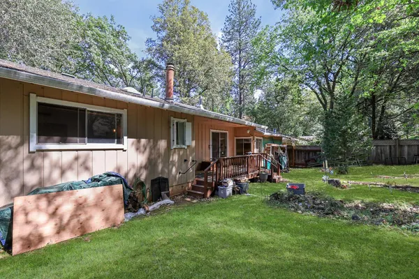 a backyard of a house with barbeque oven and outdoor seating