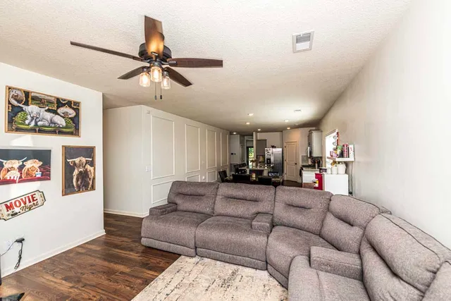 a living room with furniture and a ceiling fan