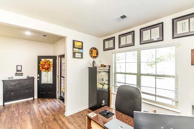 a workspace with wooden floor and windows