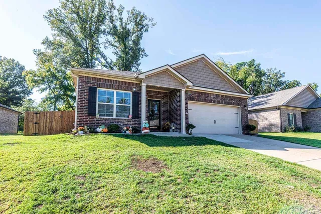a view of a house with a yard and large tree