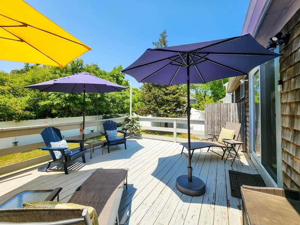12 Peaceful Lane Wareham, MA 02538 - Photo 29 of 41 a view of a patio with couches table and chairs under an umbrella