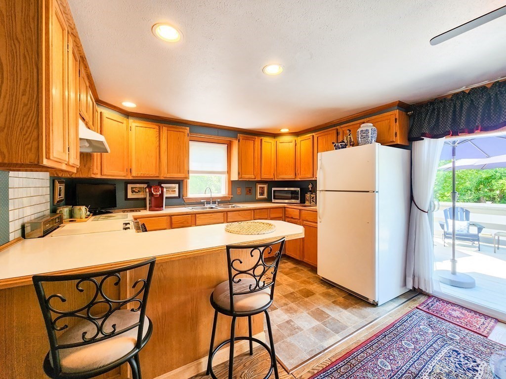 12 Peaceful Lane Wareham, MA 02538 - Photo 9 of 41 a kitchen with stainless steel appliances granite countertop a refrigerator a stove a sink dishwasher and a dining table with wooden floor