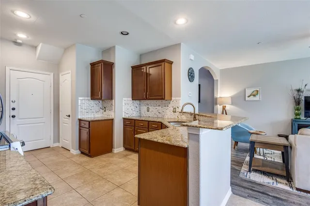 a large kitchen with a stove a sink dishwasher a microwave oven and a dining table with wooden floor