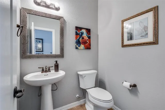 a bathroom with a toilet a sink and mirror