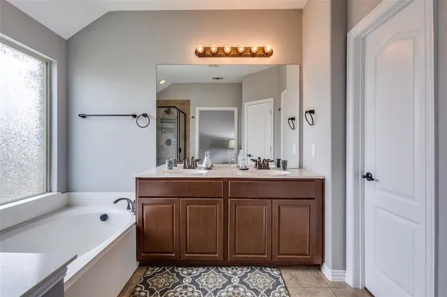 a bathroom with a tub sink and mirror