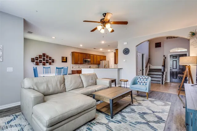 a living room with furniture kitchen view and a chandelier