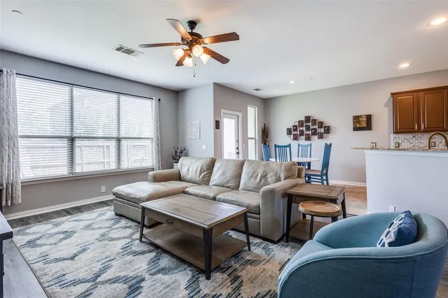 a living room with furniture a flat screen tv and a large window