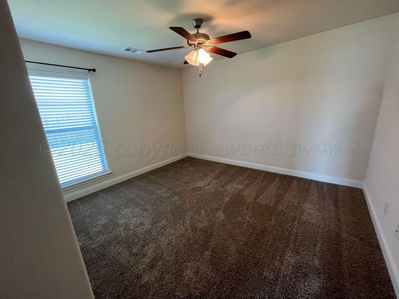 7206 Sinclair Street Amarillo, TX 79119 - Photo 14 of 21 an empty room with windows and fan