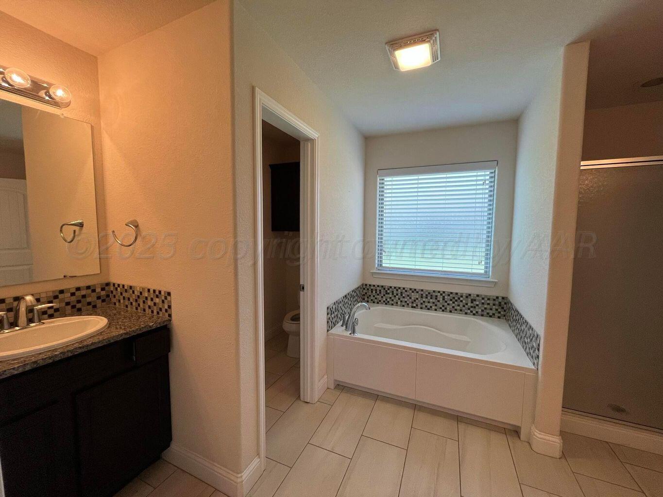 7206 Sinclair Street Amarillo, TX 79119 - Photo 9 of 21 a bathroom with a tub sink and mirror