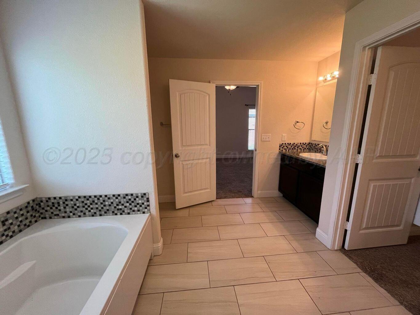 7206 Sinclair Street Amarillo, TX 79119 - Photo 10 of 21 a bathroom with a bathtub and a shower