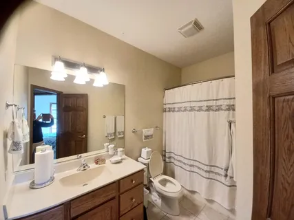 a bathroom with a sink mirror vanity and toilet