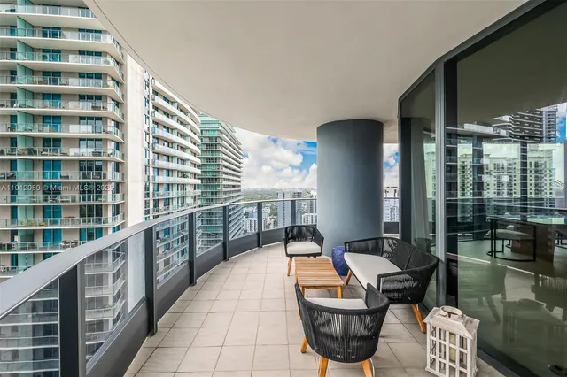 a balcony with table and chairs