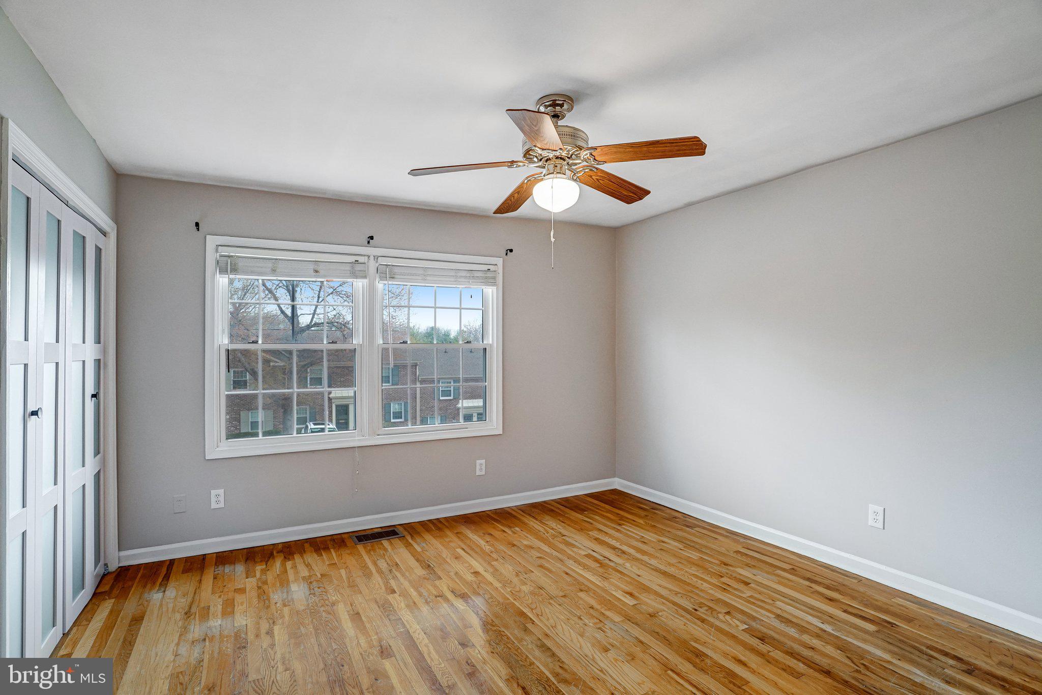8396 Forrester Boulevard, Unit 555 Springfield, VA 22152 - Photo 15 of 24 a view of an empty room with wooden floor and a window