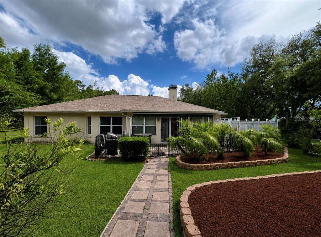 1995 East Newhaven Street Inverness, FL 34453 - Photo 33 of 48 a front view of a house with a garden and trees