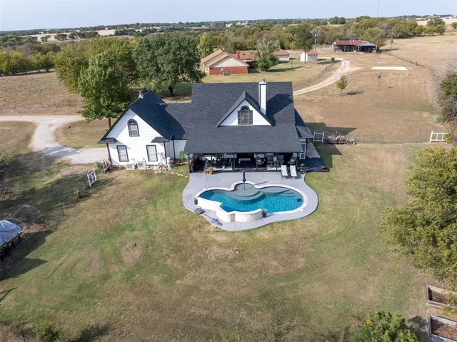 an aerial view of a house with yard swimming pool and outdoor seating