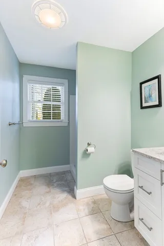 a bathroom with a toilet a sink and a window