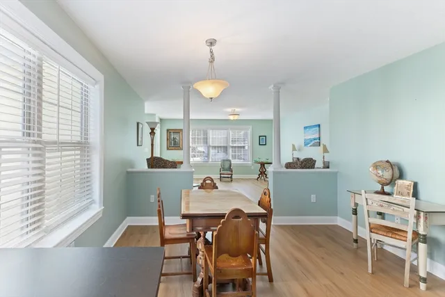 a dining room with furniture a chandelier and wooden floor