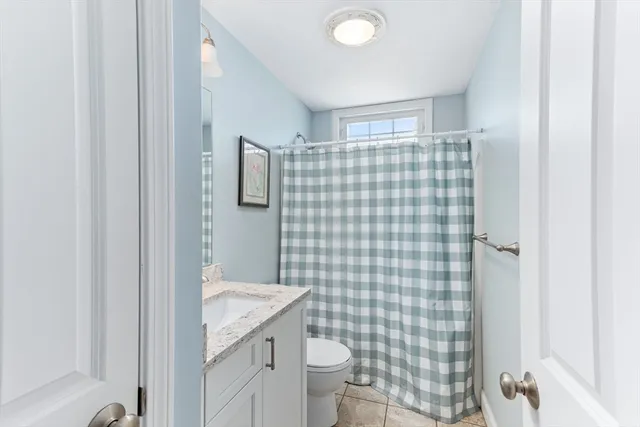 a bathroom with a granite countertop toilet and a sink