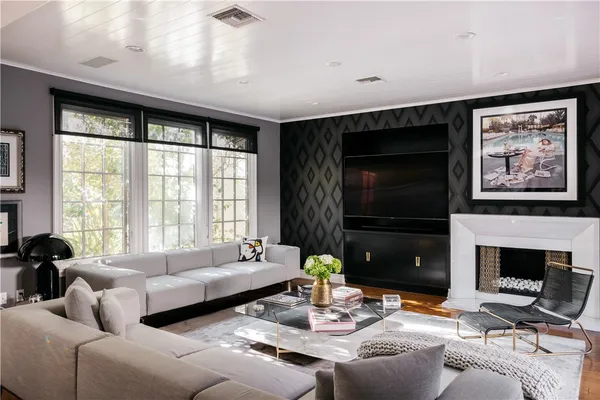 a living room with furniture a large window and a flat screen tv