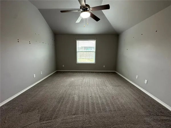 an empty room with a window and a ceiling fan
