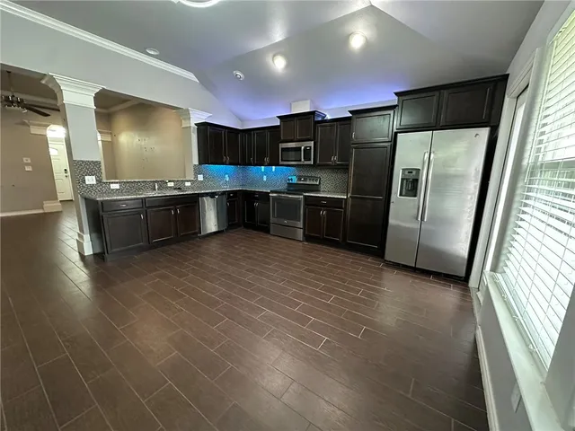 a large kitchen with stainless steel appliances a large counter top