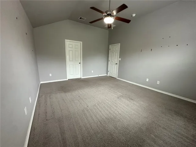 an empty room with a ceiling fan and a window