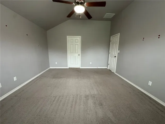 an empty room with a chandelier fan