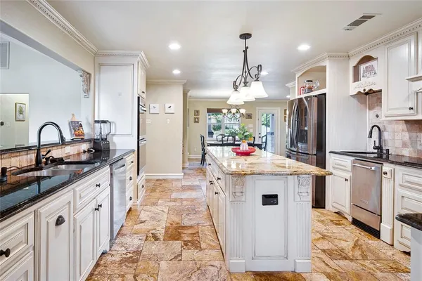 a kitchen with stainless steel appliances granite countertop a sink stove and refrigerator