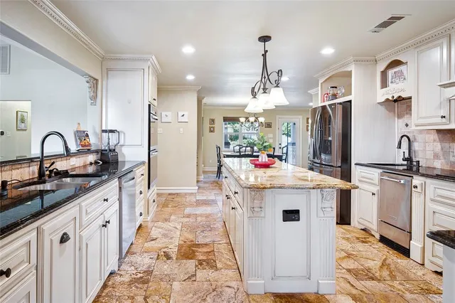 a kitchen with stainless steel appliances granite countertop a sink stove and refrigerator