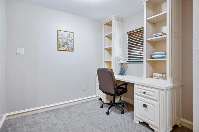 a view of a workspace with furniture and a window